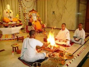 Priests conducting a pooja around a sacred fire in a temple